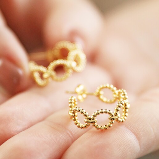 Model Holding Beaded Chain Hoop Earrings in Gold