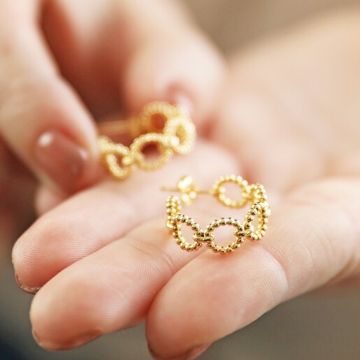 Model Holding Gold Beaded Chain Hoop Earrings