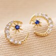 Clear and Blue Crystal Moon Stud Earrings in Gold on Beige Fabric