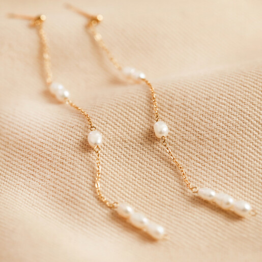 Gold Stainless Steel and Pearl Drop Earrings on fabric