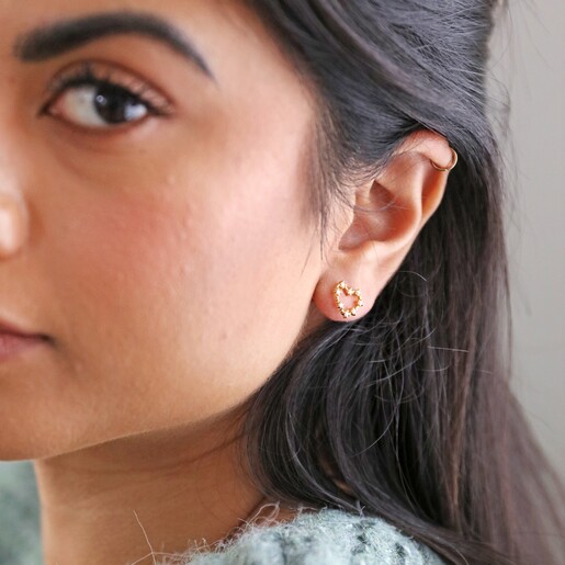 model wearing Mismatched Crystal Heart Earrings in Gold
