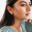 side profile of model wearing Mismatched Crystal Heart Earrings in Rose Gold