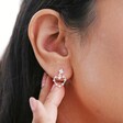 close up of model touching ear highlighting drop stud from Mismatched Crystal Heart Earrings in Silver