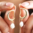 Model Holding Organic Circle Pearl Drop Earrings in Gold