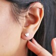 close up of model's ear wearing Small Hammered Heart Stud Earrings in Silver