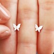 Model Holding Tiny Butterfly Stud Earrings in Silver
