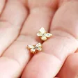 Model Holding White Enamel Butterfly Stud Earrings in Gold