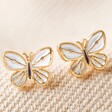 White Enamel Butterfly Stud Earrings in Gold on Fabric
