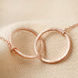 Close Up of Brushed Interlocking Hoop Necklace in Rose Gold