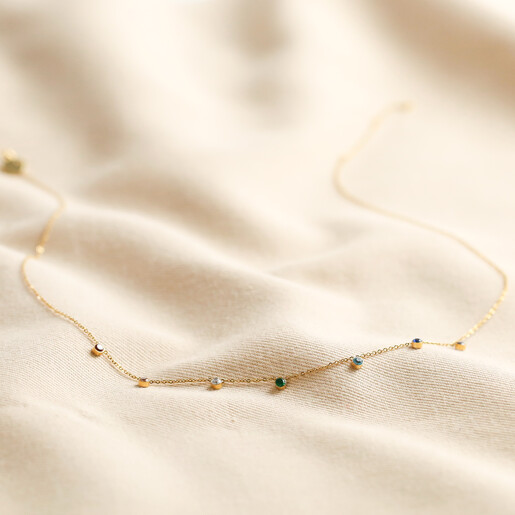 Full length of Gold Stainless Steel Rainbow Crystals Necklace on fabric background