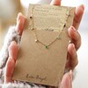 model holding Gold Stainless Steel Rainbow Crystals Necklace in packaging