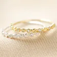 Two Sterling Silver Dotted Crystal Band Rings on Fabric, one gold plated