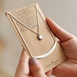 Model Holding Sun and Horn Layered Necklace in Silver in Packaging