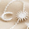 Close Up of Sun and Moon Chain Necklace in Silver on Beige Fabric