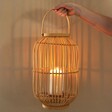 Hanging Rattan Lantern with Candle Holder on Wood Surface