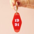 Model Holding Personalised Bold Date Acrylic Keyring in Red and Pink