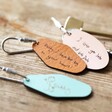 Three Personalised Handwriting Leather Tag Keyrings on Wooden Table