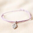 Hamsa Hand Charm Cord Friendship Bracelet in Purple on fabric background