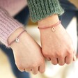 two Models Wearing Hamsa Hand Charm Cord Friendship Bracelet