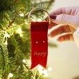 Model Holding Personalised Red Ribbon Decoration with Stud Earrings