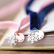 Personalised Snowflake Charm Ribbon Bookmark laying in open book