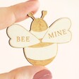 Close up of model holding Wooden Bee Mine Bumblebee Token with thumb and forefinger 