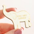 Close up of model holding Wooden You Are Loved Elephant Token