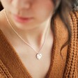 model wearing personalised sterling silver heart charm necklace with swarovski crystal wearing thick knit jumper