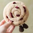 Aerial view of model holding Jellycat Amuseable Pain Au Raisin Soft Toy