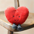 Jellycat Amuseable Red Heart Soft Toy sitting on a chair