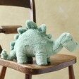 Jellycat Fossilly Stegosaurus Soft Toy on Wooden Chair
