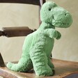 Jellycat Fossilly T-Rex Soft Toy on wooden chair