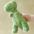 Model holding Jellycat Fossilly T-Rex Soft Toy