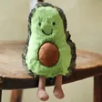 Jellycat Small Amuseable Avocado Soft Toy Sat on Wooden Table