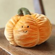 Jellycat Vivacious Vegetable Pumpkin Soft Toy sat on brown wooden chair