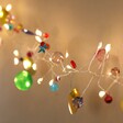 Illuminated Folklore Colourful Charm Wire String Lights Against Wall