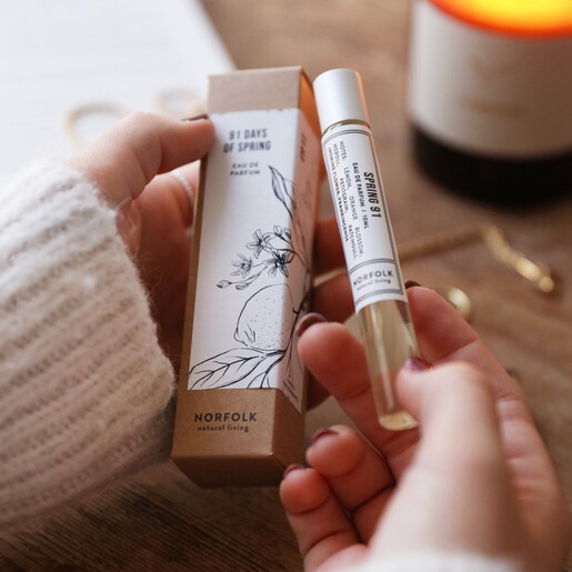 Model Holding Norfolk Natural Living 91 Days of Spring Rollerball Parfum and Packaging