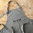 Personalised The Legend Grey Apron Laid Out on Wooden Table