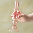 Model Holding Sass & Belle Bubble Candlestick Holder in Pink in front of green background