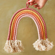 Model holding Sass & Belle Cotton Earth Rainbow Wall Decoration