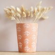 Bee Terracotta Plant Pot containing lagurus bunny tails on wooden table