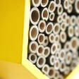 close up of wooden tubes in wooden bee house