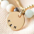 close up of K & M personalisation on personalised disc charm for Personalised Semi-Precious Stone Bead and Chain Anklet in Pastel Blue