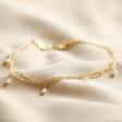Set of 2 Pearl and Chain Anklets in Gold on fabric background