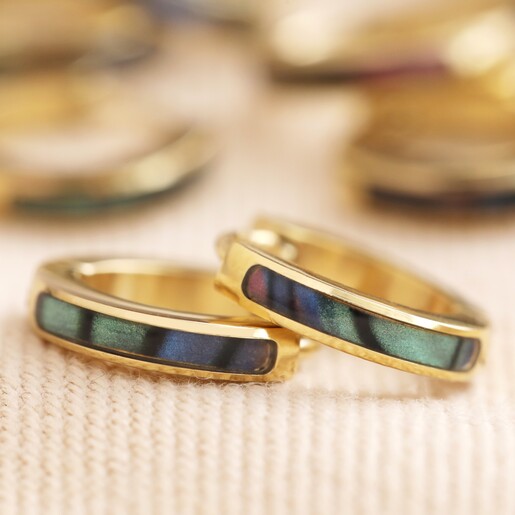 Shell Black Resin Infill Huggie Hoop Earrings in Gold on Beige Fabric