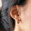 Model Wearing Shell Black Resin Infill Huggie Hoop Earrings in Gold