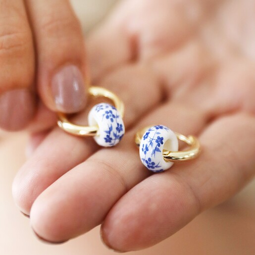 Model Holding Blue Willow Bead Hoop Earrings in Gold