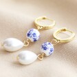 Blue Willow and Pearl Drop Huggie Earrings in Gold on Beige Fabric