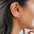 Close up of side profile of model wearing Rainbow Geometric Enamel Hoop Earrings in Gold