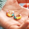 model holding Rainbow Geometric Enamel Hoop Earrings in Gold